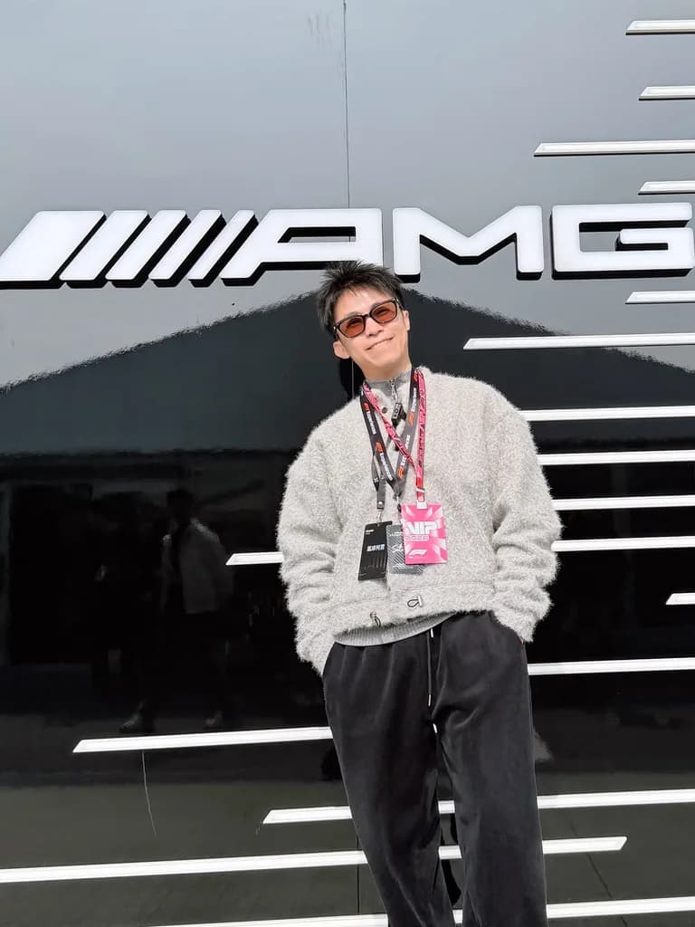 氣球柯男在鈴鹿賽道 F1 圍場內車隊 hospitality 建築前，掛 VIP 2026 通行證