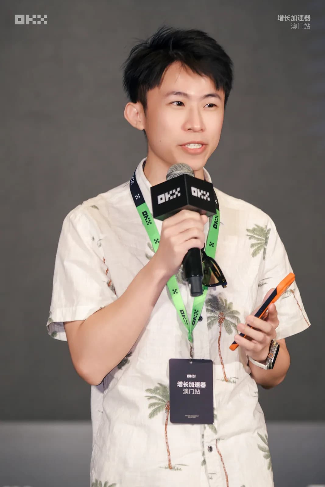 氣球柯男在 OKX 增長加速器澳門站手持麥克風分享，掛澳門站識別證