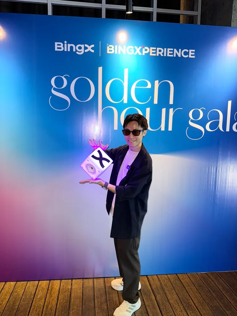 氣球柯男在 BingX BINGXPERIENCE Golden Hour Gala 背板前,手托 BingX 方塊造型物