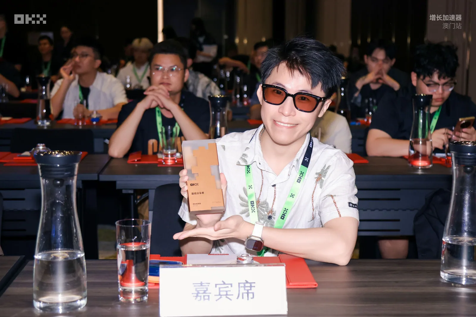 氣球柯男在 OKX 增長加速器澳門站嘉賓席手持「最佳分享者」獎座
